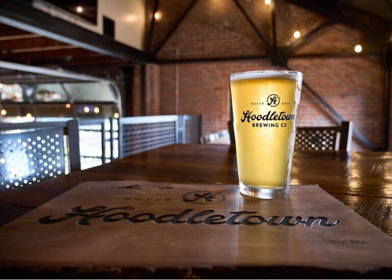 Hoodletown Belgian Single beer in a pint glass on a table.