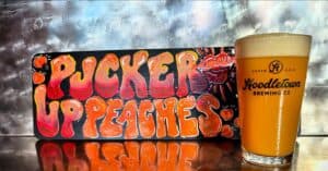 Hoodletown's Pucker Up Peaches beer in a pint glass.