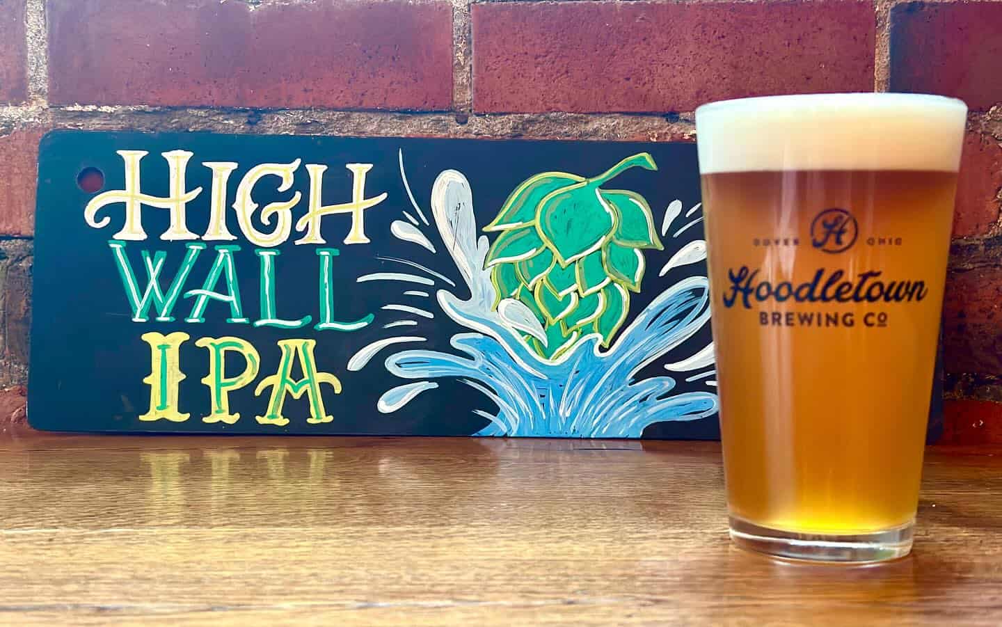 Image of Hoodletown Brewery's High Wall IPA in a pint glass with a sign next to it saying "High Wall IPA".